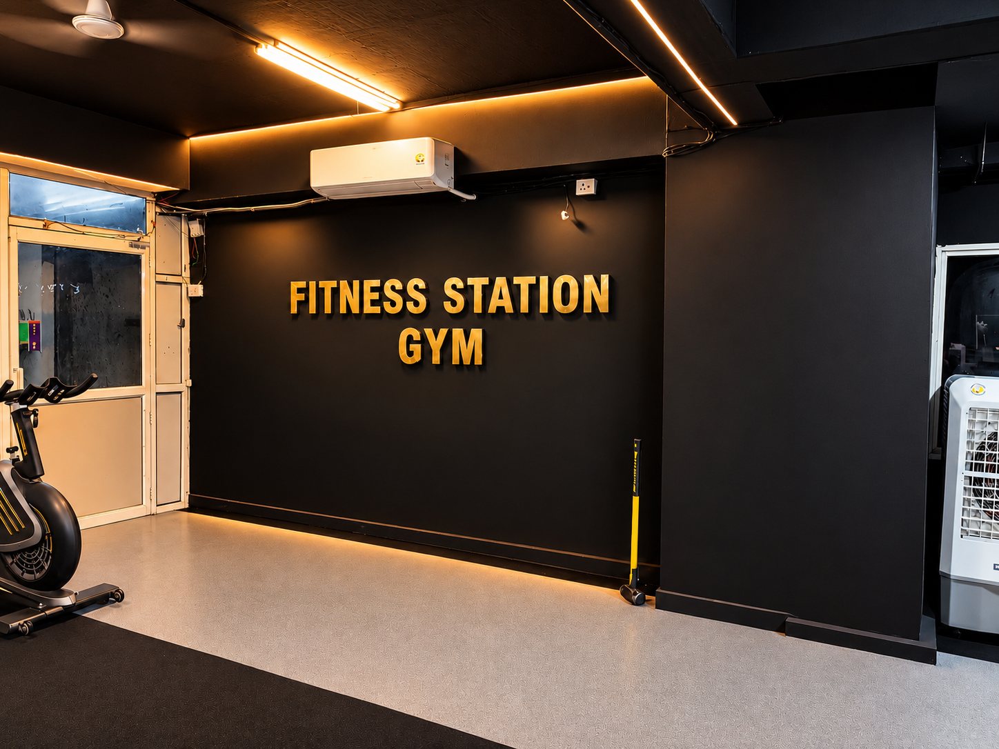 Fitness Station Gym gold sign on the black wall